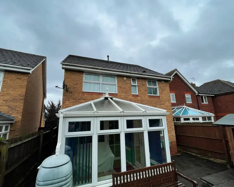 Victorian conservatory with a polycarbonate roof on an overcast day